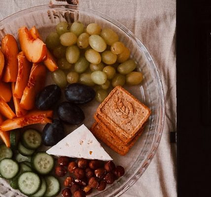 A delightful snack plate with fruits, cheese, and a laptop for a healthy lifestyle.